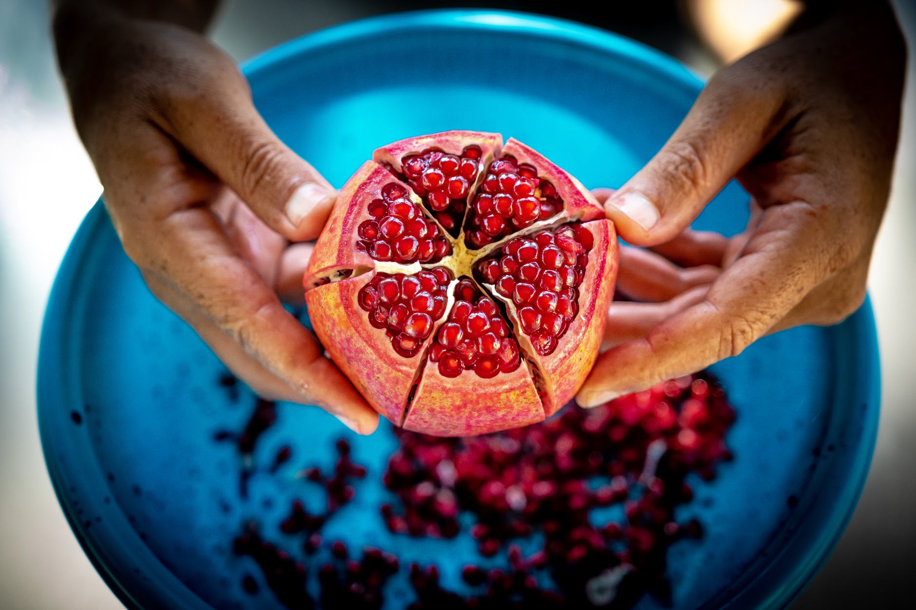 close up photo of person holding pomegranate fruit