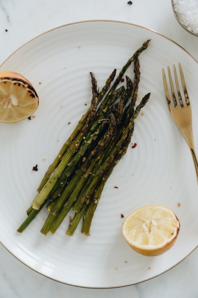 close up photo of asparagus beside sliced lemon